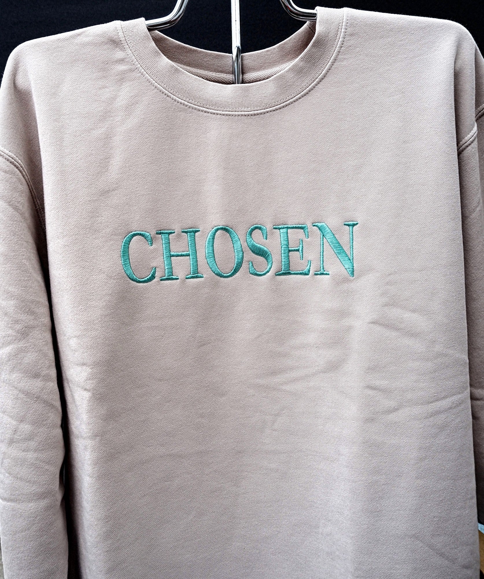 CHOSEN teal embroidered crewneck sweatshirt in warm beige on a hanger