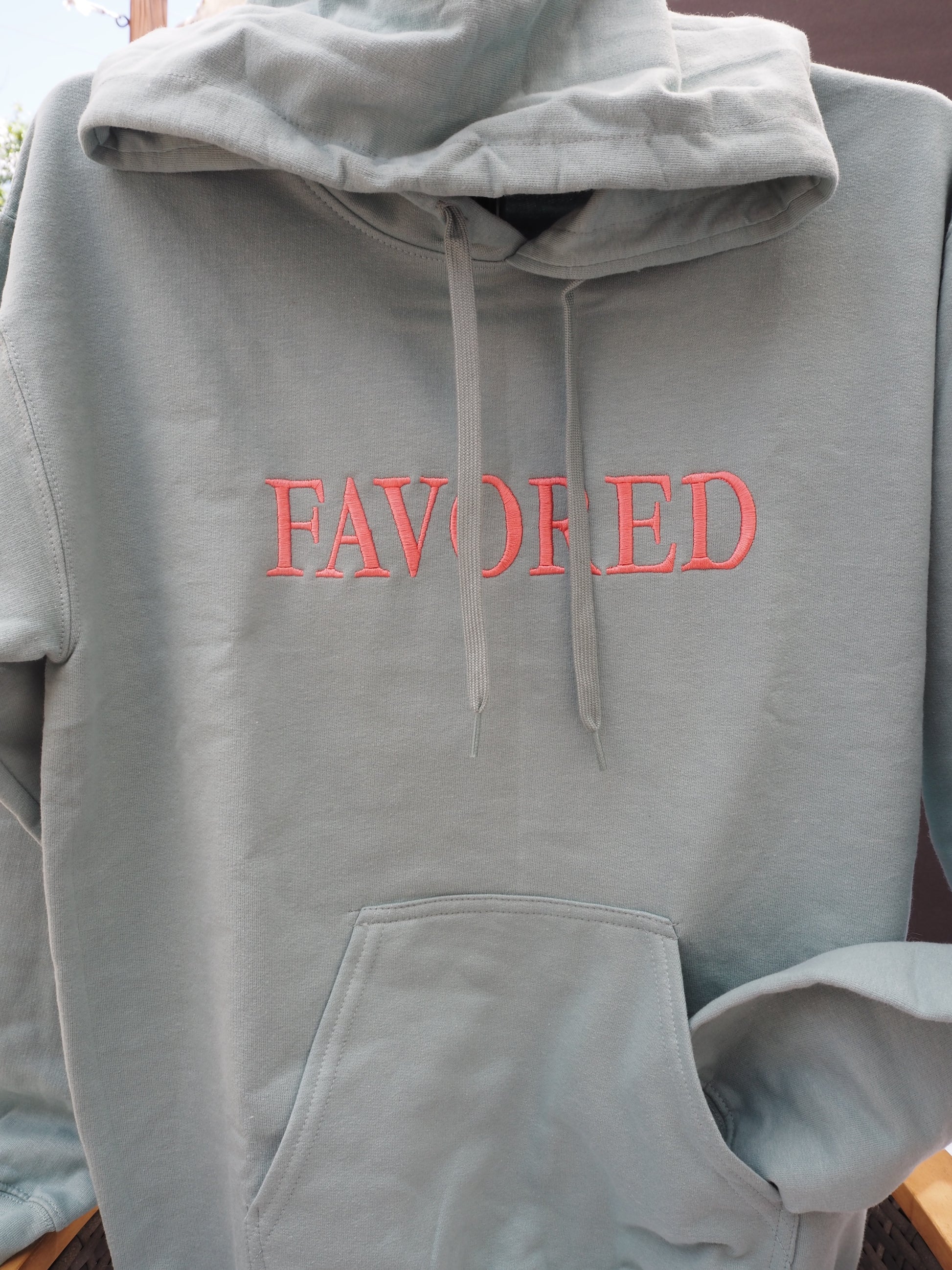 FAVORED embroidered hoodie in sage green with red lettering on front