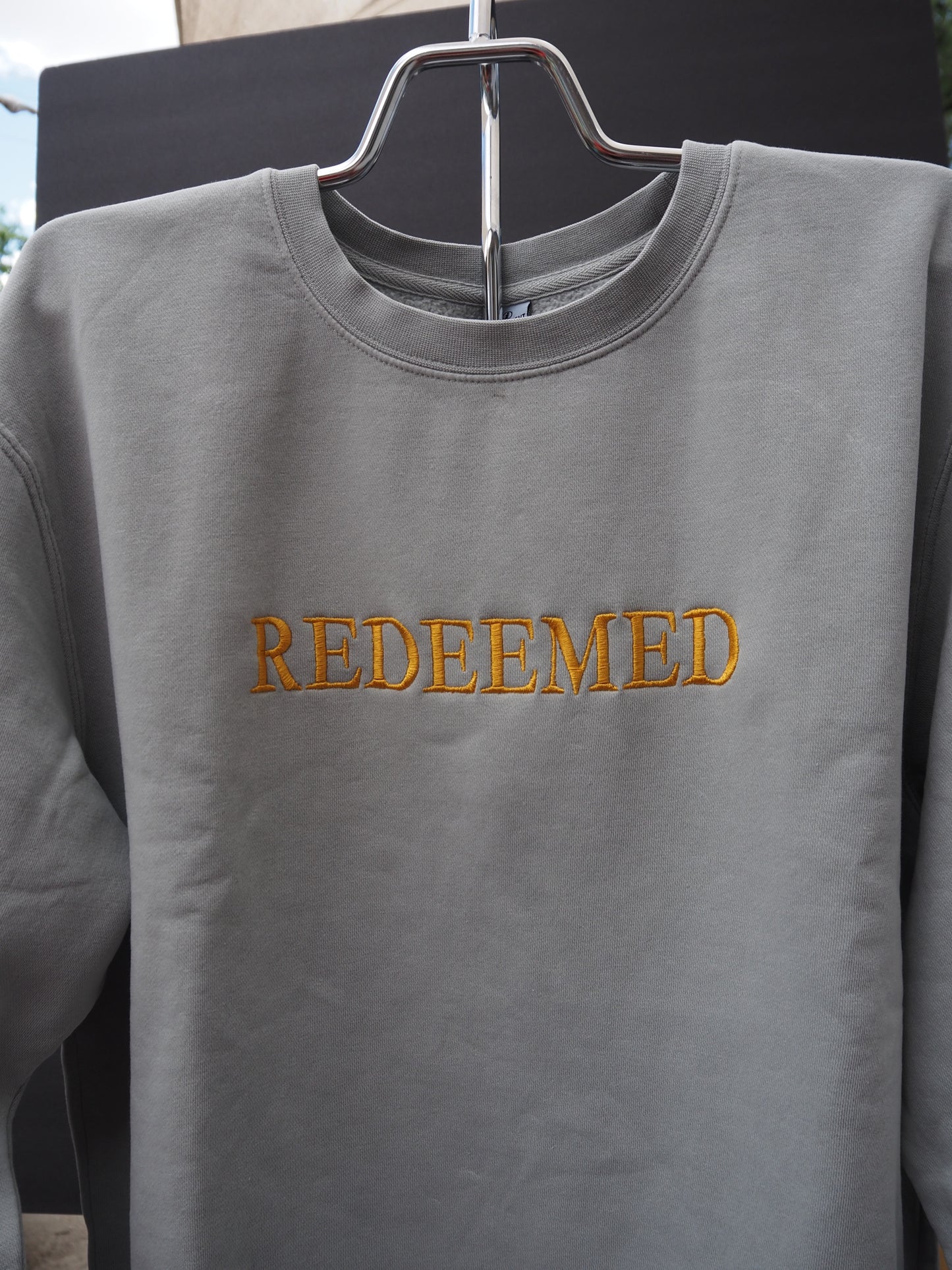 REDEEMED embroidered crewneck sweatshirt in slate gray with gold lettering