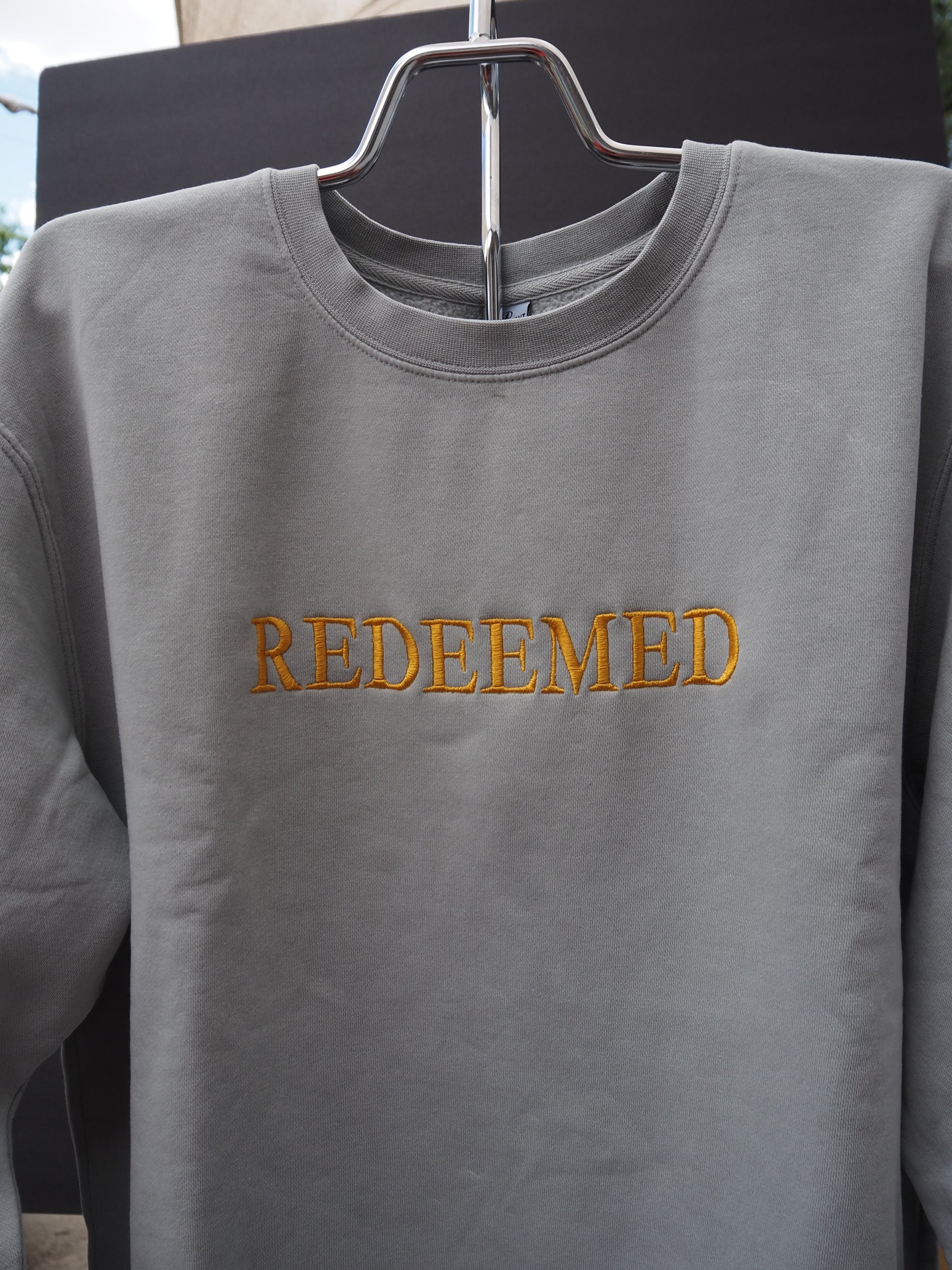 REDEEMED embroidered crewneck sweatshirt in slate gray with gold lettering