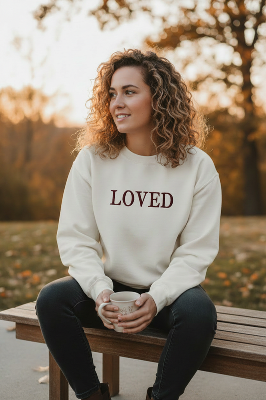 Lifestyle photo of woman wearing LOVED cream crewneck from the front