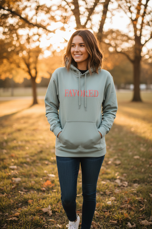 Lifestyle photo of woman wearing FAVORED sage green hoodie outdoors